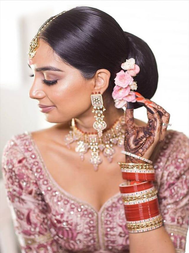 Photo of Bride wearing pink lehenga with contrasting jewellery.